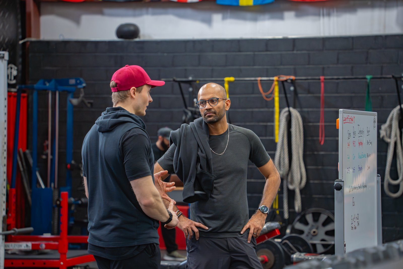 Coach reviewing a personalized training plan on the whiteboard with an adult member